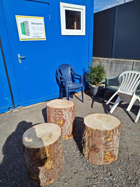 Sessel und Tische vor Containern