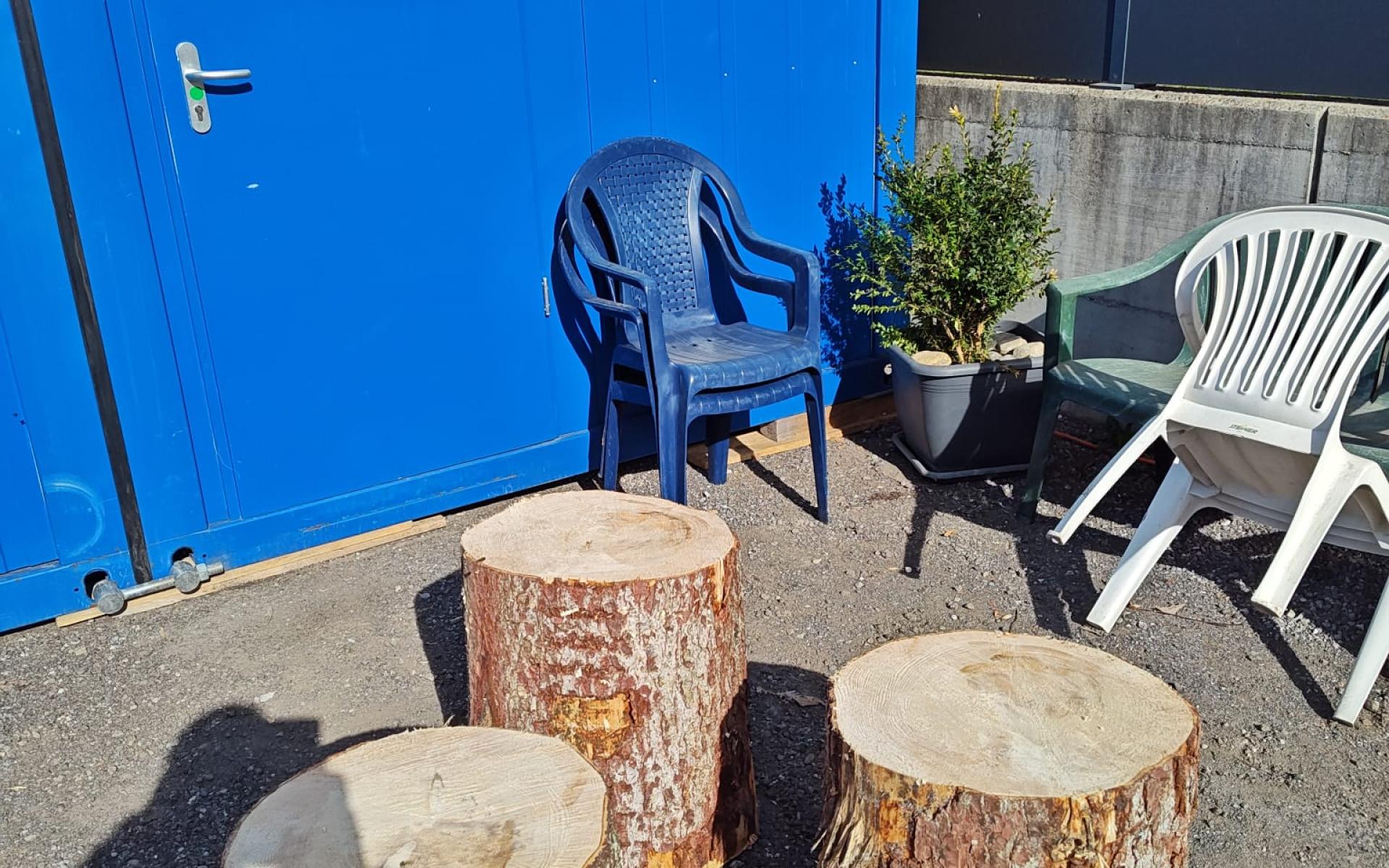 Sessel und Tische vor Containern